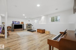 Spacious lower-level room featuring wood-finish flooring, recessed lighting, and a window - 