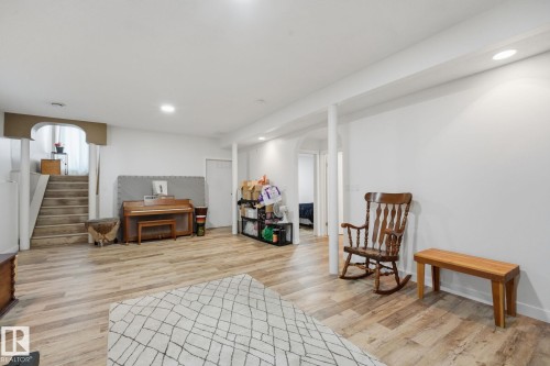 Spacious room featuring wood-finish flooring, recessed lighting, and white walls - 5132 157 Avenue Nw, Edmonton, AB 