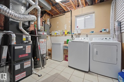 Utility area featuring a furnace, water heater, and tiled flooring - 5132 157 Avenue Nw, Edmonton, AB 
