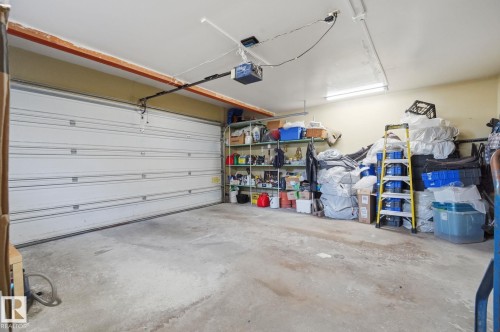Spacious garage featuring a sectional garage door, concrete flooring, and overhead lighting - 5132 157 Avenue Nw, Edmonton, AB 