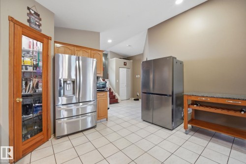 Kitchen featuring light wood cabinetry, stainless steel appliances, and light-toned floor tiling - 5132 157 Avenue Nw, Edmonton, AB 