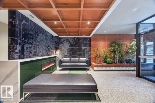 Wood-finish coffered ceiling, recessed lighting, accent wall with map graphic, built-in electric fireplace, and interior planter with brick-patterned wall - #1102 9916 113 St Nw, Edmonton, AB 