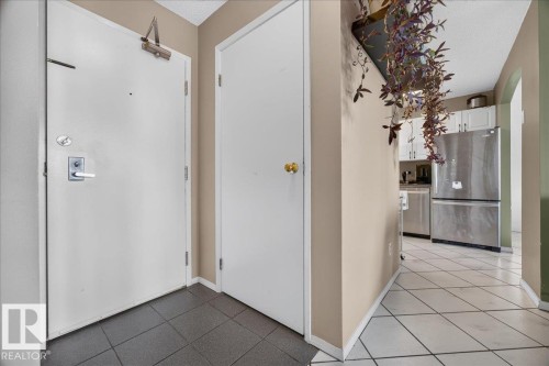 Entryway featuring a security door, adjacent storage door, and tiled flooring - #1102 9916 113 St Nw, Edmonton, AB 
