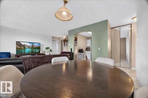 Dining area with overhead lighting, archway entry, and mirrored closet doors - #1102 9916 113 St Nw, Edmonton, AB 
