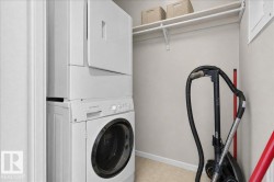 Stackable washer and dryer, built-in shelving, and light-toned wall paint - 