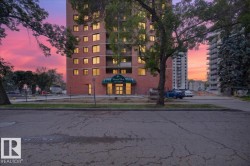 Brick exterior high-rise building with multiple windows, framed by mature trees - 