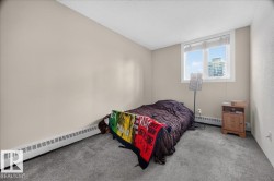 Neutral wall color, carpeted flooring, window with white trim, baseboard heating, and textured ceiling - 