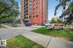 Brick-clad high-rise building with a portico entrance and multiple balconies - 