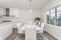 Dining area with wood-finish flooring, a contemporary pendant light fixture, and large windows - 