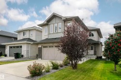 Two-story exterior with a gabled roof, stucco and shingle siding, an integrated garage, and a concrete driveway - 