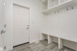 Built-in bench seating with storage, integrated wall hooks, overhead shelving, and large format floor tiling - 