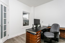 Wood-finish flooring, white walls, frosted glass panel door, and a single window - 