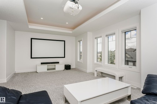 Recessed lighting, tray ceiling, integrated projection screen, multiple windows, and patterned carpeting - 9107 181 Avenue Nw, Edmonton, AB 