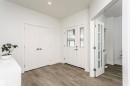 Entryway featuring light wood-finish flooring, a white paneled entry door with frosted glass inserts, and a pair of white double doors with contemporary hardware - 9107 181 Avenue Nw, Edmonton, AB 