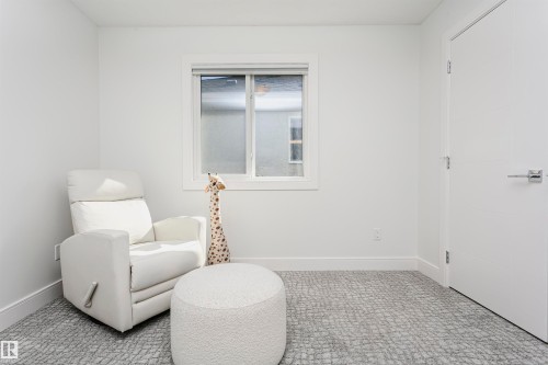 Wall-to-wall patterned carpet, contemporary white door with chrome hardware, white trim, and a double-pane window - 9107 181 Avenue Nw, Edmonton, AB 