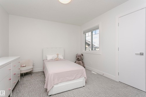 Recessed lighting, light gray patterned carpeting, white walls, white trim, and a window with white casing - 9107 181 Avenue Nw, Edmonton, AB 