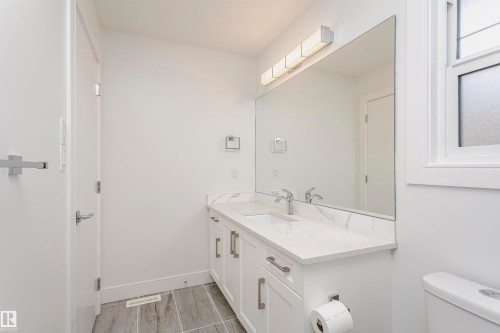 Dual vanity with white cabinetry, polished chrome hardware, and undermount sinks - 9107 181 Avenue Nw, Edmonton, AB 