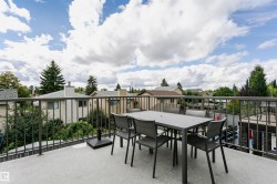 Expansive outdoor terrace featuring a gray textured surface and dark metal railings - 