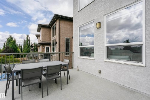 Expansive outdoor patio with durable railing, textured exterior finish, and a wall-mounted light fixture - 9107 181 Avenue Nw, Edmonton, AB 