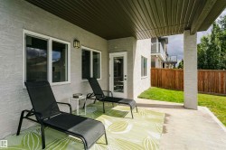 Covered concrete patio with white stucco exterior and permanent outdoor lighting - 