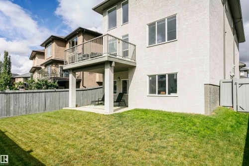 Expansive backyard featuring a manicured lawn, full fencing, and a ground-level patio - 9107 181 Avenue Nw, Edmonton, AB 