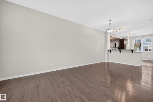 Hardwood flooring, recessed lighting, central pendant light fixture, dark wood cabinetry, stainless steel appliances - #72 603 Watt Bv Sw Sw, Edmonton, AB 