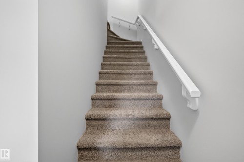 Carpeted staircase with white wall-mounted handrail - #72 603 Watt Bv Sw Sw, Edmonton, AB 