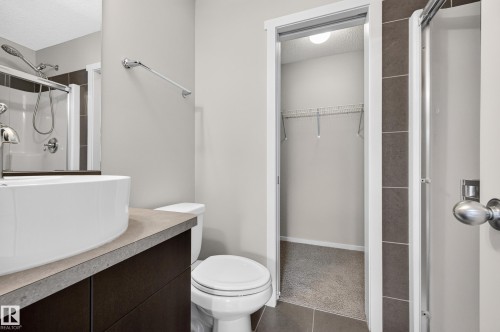 Modern vanity with a vessel sink, dark cabinetry, and a light-toned countertop - #72 603 Watt Bv Sw Sw, Edmonton, AB 