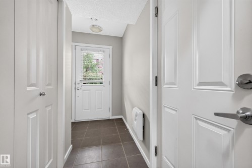 Tiled entry floor, white paneled doors, and ceiling-mounted light fixture - #72 603 Watt Bv Sw Sw, Edmonton, AB 