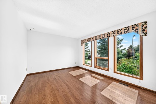 Rich wood-finish flooring complements the neutral wall tones - 4208 Ramsay Road Nw, Edmonton, AB 