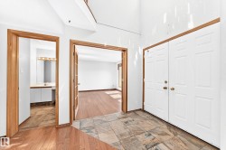 Entryway featuring a double door, mixed-material flooring, and wood-trim doorways - 