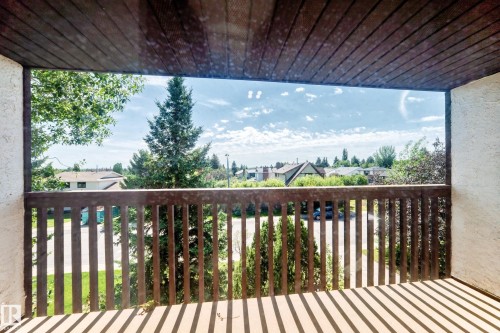Balcony with wood-paneled ceiling, wood railing, and textured wall finish - 4208 Ramsay Road Nw, Edmonton, AB 