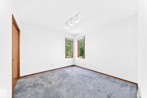 Wall-to-wall carpeting, wood-finish trim, track lighting, and wood-framed windows - 4208 Ramsay Road Nw, Edmonton, AB 