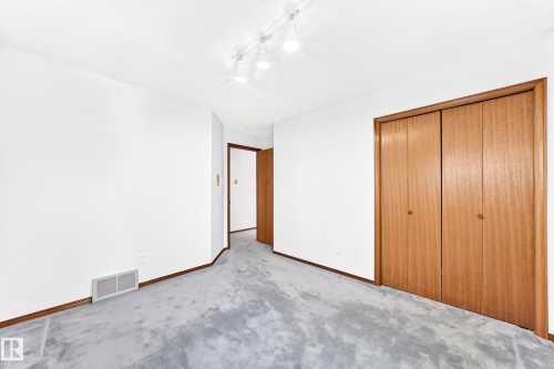 Neutral carpet flooring with light-toned walls - 4208 Ramsay Road Nw, Edmonton, AB 