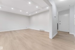 Recessed lighting illuminates the coffered ceiling and light wood-finish flooring - 