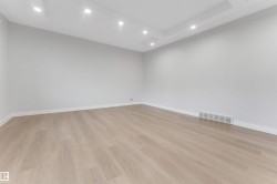 Recessed lighting, tray ceiling, light wood-finish flooring, and crisp white walls - 