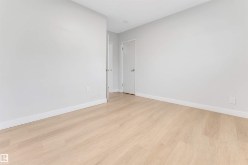 Light wood-finish flooring and neutral wall tones - 7928 82 Avenue Nw, Edmonton, AB 