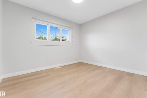 Light-toned wood-finish flooring with white baseboards - 7928 82 Avenue Nw, Edmonton, AB 