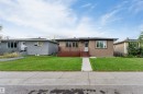 Siding exterior with a white entry door, front deck, and a concrete walk - 7928 82 Avenue Nw, Edmonton, AB 
