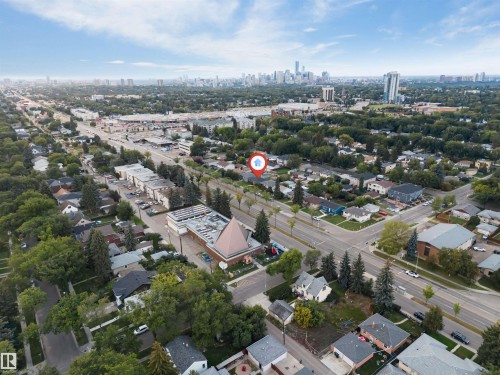 Aerial perspective showcasing residential streets, mature trees, and a distant city skyline - 7928 82 Avenue Nw, Edmonton, AB 