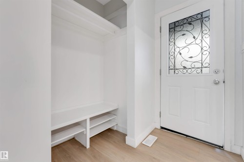 Entryway featuring a decorative glass panel door, built-in shelving, and wood-finish flooring - 7928 82 Avenue Nw, Edmonton, AB 