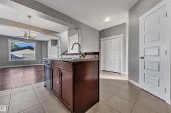 Kitchen island with built-in dishwasher, stainless steel faucet, and granite-style countertop - 