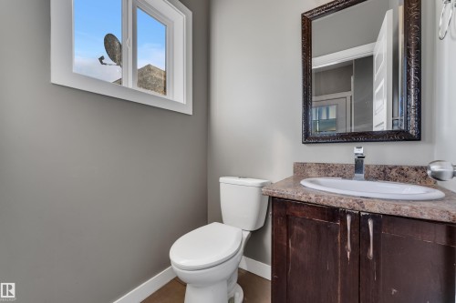 Built-in vanity with a surface-mounted sink, wood-finish cabinetry, and a patterned countertop - 11421 82 Street Nw, Edmonton, AB 