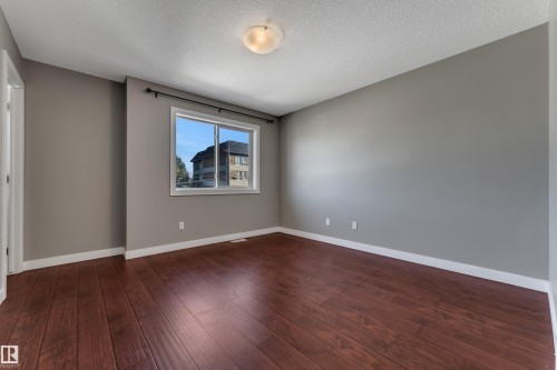 Wood-finish flooring, neutral grey wall paint, white trim, and a ceiling-mounted light fixture - 11421 82 Street Nw, Edmonton, AB 