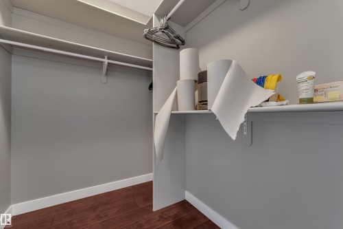 Utility room featuring exposed wood-finish flooring, gray painted walls, and ceiling-mounted mechanical systems - 11421 82 Street Nw, Edmonton, AB 