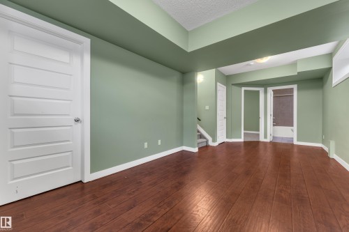 Expansive room featuring wood-finish flooring, recessed ceiling details, and white trim - 11421 82 Street Nw, Edmonton, AB 