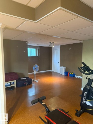 Recessed drop ceiling, neutral tone walls, wood-finish flooring, white paneled door, and recessed lighting - 124 Ward Crescent Nw Nw, Edmonton, AB 