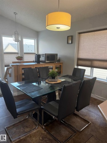 Vaulted ceiling, drum pendant light, recessed windows, wood-finish flooring, and built-in cabinetry with glass doors - 124 Ward Crescent Nw Nw, Edmonton, AB 