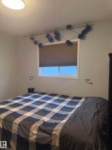 Recessed window with pleated blinds, integrated ceiling light fixture, and wall-mounted sconces - 124 Ward Crescent Nw Nw, Edmonton, AB 