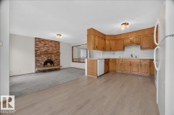 Kitchen with wood-finish cabinetry, white appliances, and laminate flooring - 